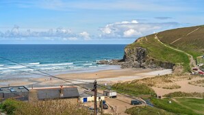 Une vue sur la côte, avec une plage, des falaises rocheuses et un ciel dégagé.