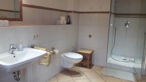 Un baño con lavamanos, inodoro y ducha.