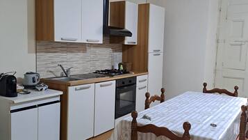 Een koelkast, kookgerei, borden en bestek