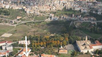 An aerial view of a town with a prominent church, surrounded by residential buildings and green spaces.