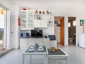 Cozy living space with a central glass-top table and flat-screen TV.