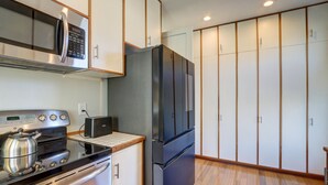 A compact kitchen with a microwave, toaster, stove, and refrigerator.