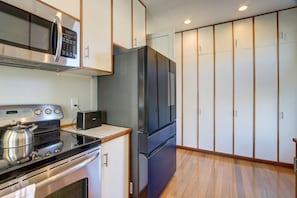 Cocina compacta con microondas, tostadora, estufa y refrigerador.