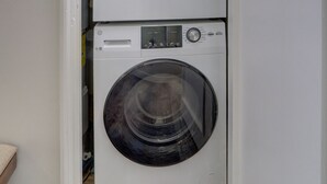 A compact, two-door laundry room with a built-in washer and dryer.