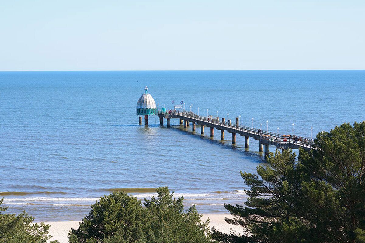 A pier extending into the water with a dome structure at the end.