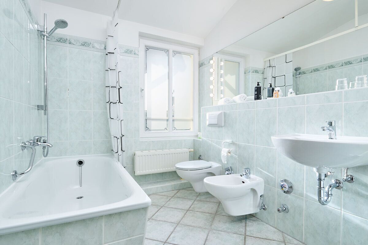 Un bagno moderno dotato di vasca, WC, bidet e lavabo.