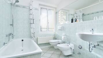 Un bagno moderno dotato di vasca, WC, bidet e lavabo.