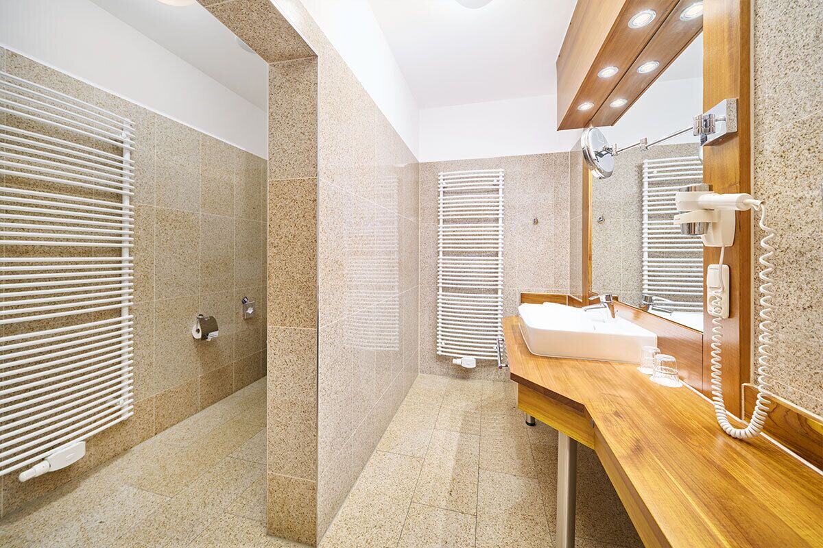 A modern bathroom with a shower, a sink, and a mirror.