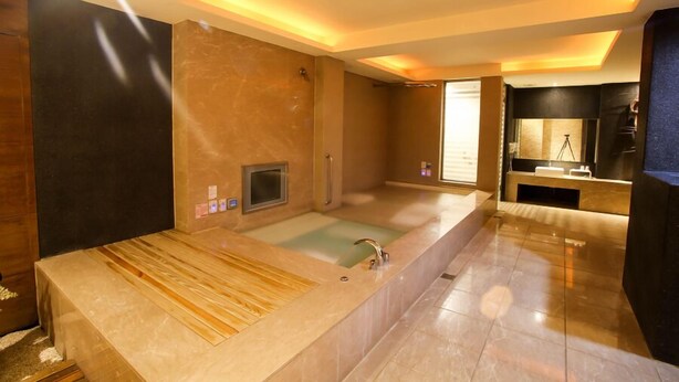 A modern bathroom with a large bathtub, a separate shower area, and a vanity with a mirror. - Hip Spa Motel (Taichung)