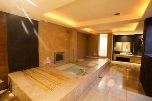 Een moderne badkamer met een ruime ligbad, een aparte douche en een wastafel met spiegel.