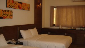 A hotel room with two beds, a bedside table with a phone, a lamp, and a window with curtains. - Hip Spa Motel (Taichung)