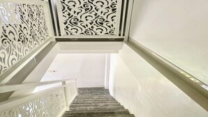 Una escalera con barandilla blanca y un panel decorativo en la parte superior.