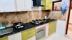 Une cuisine équipée d’une cuisinière à gaz, d’un évier et de placards.