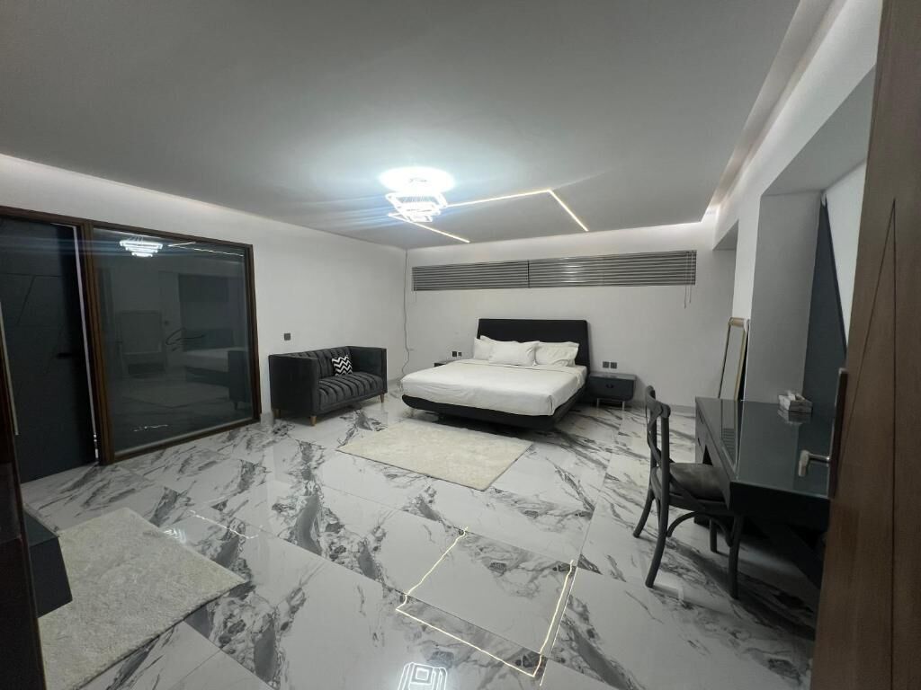 Un dormitorio moderno con cama, escritorio y silla.