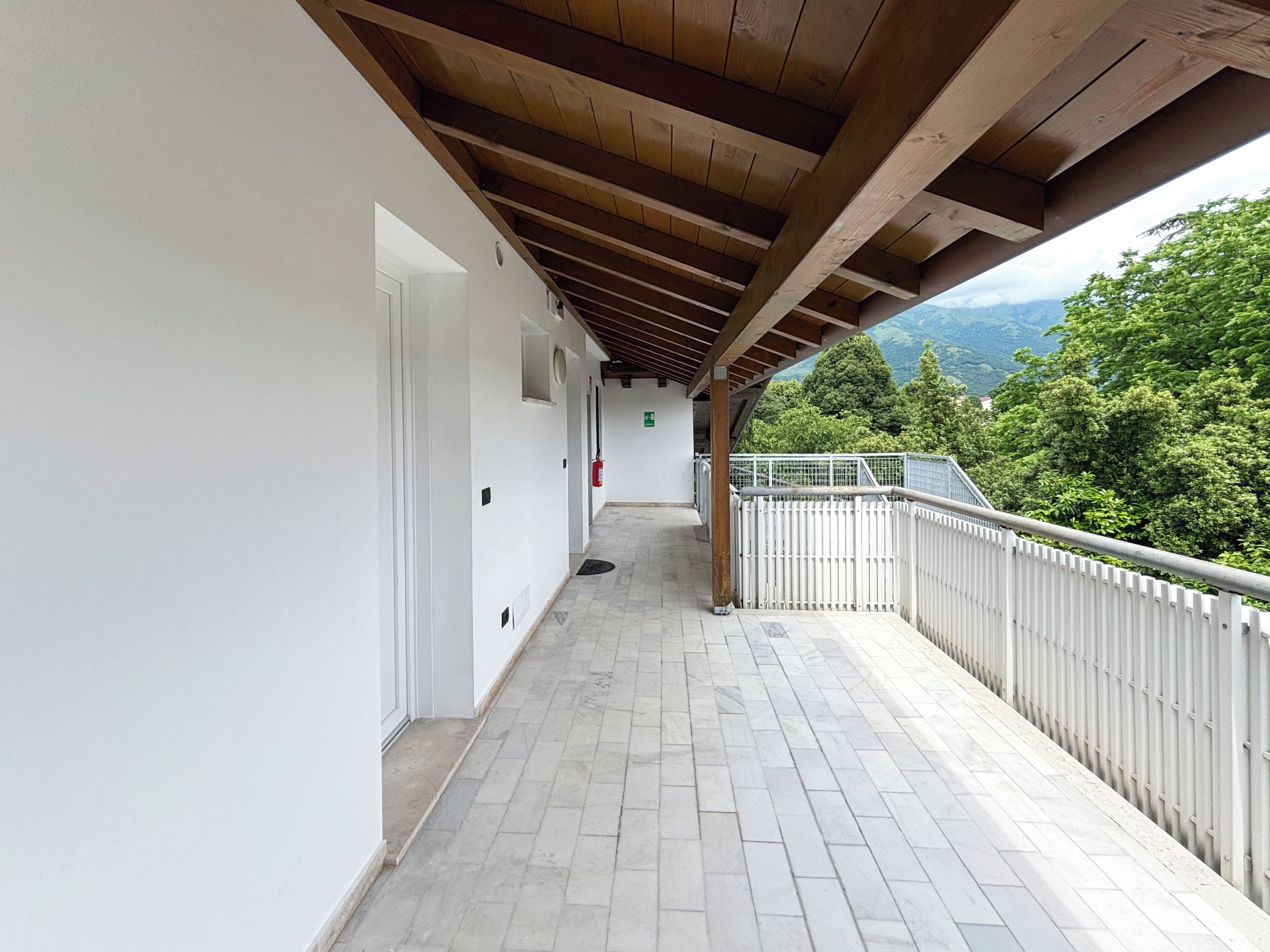 Un balcon fermé offrant une vue sur un paysage montagneux.