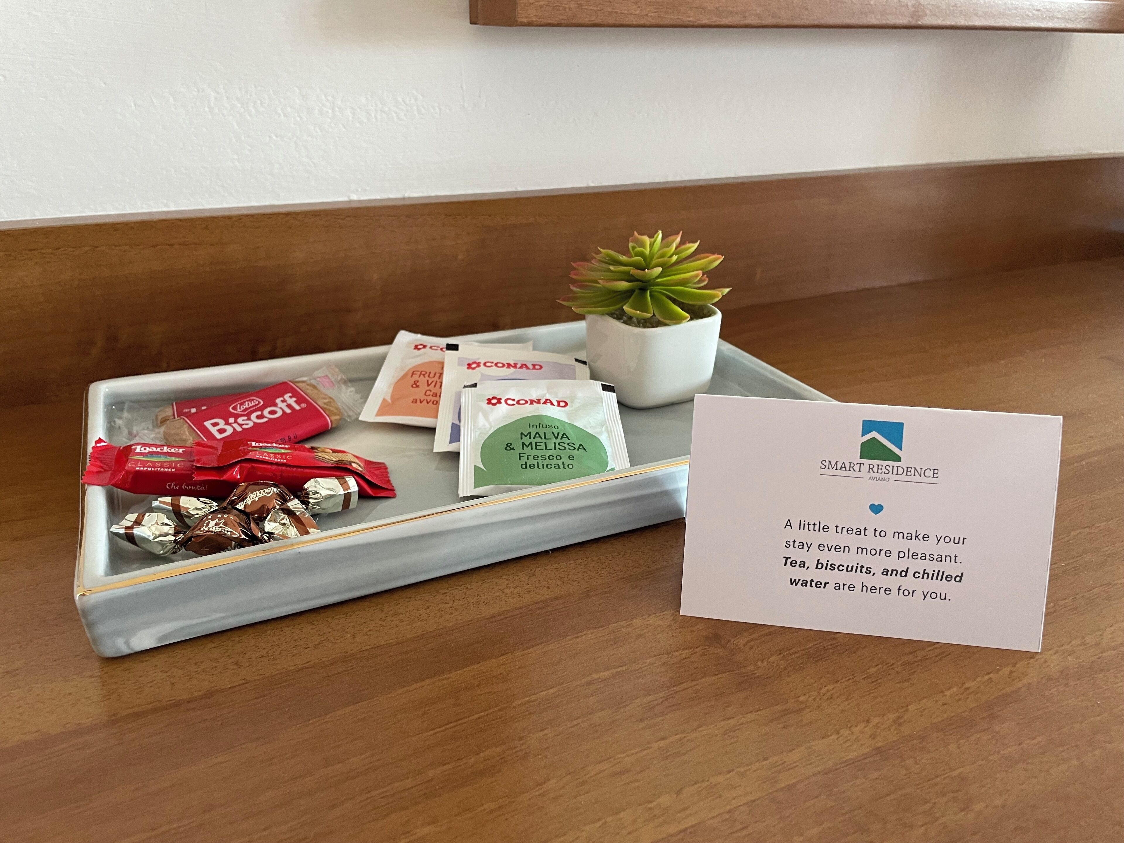 A tray with snacks and a note from SMART RESIDENCE AVIANO.