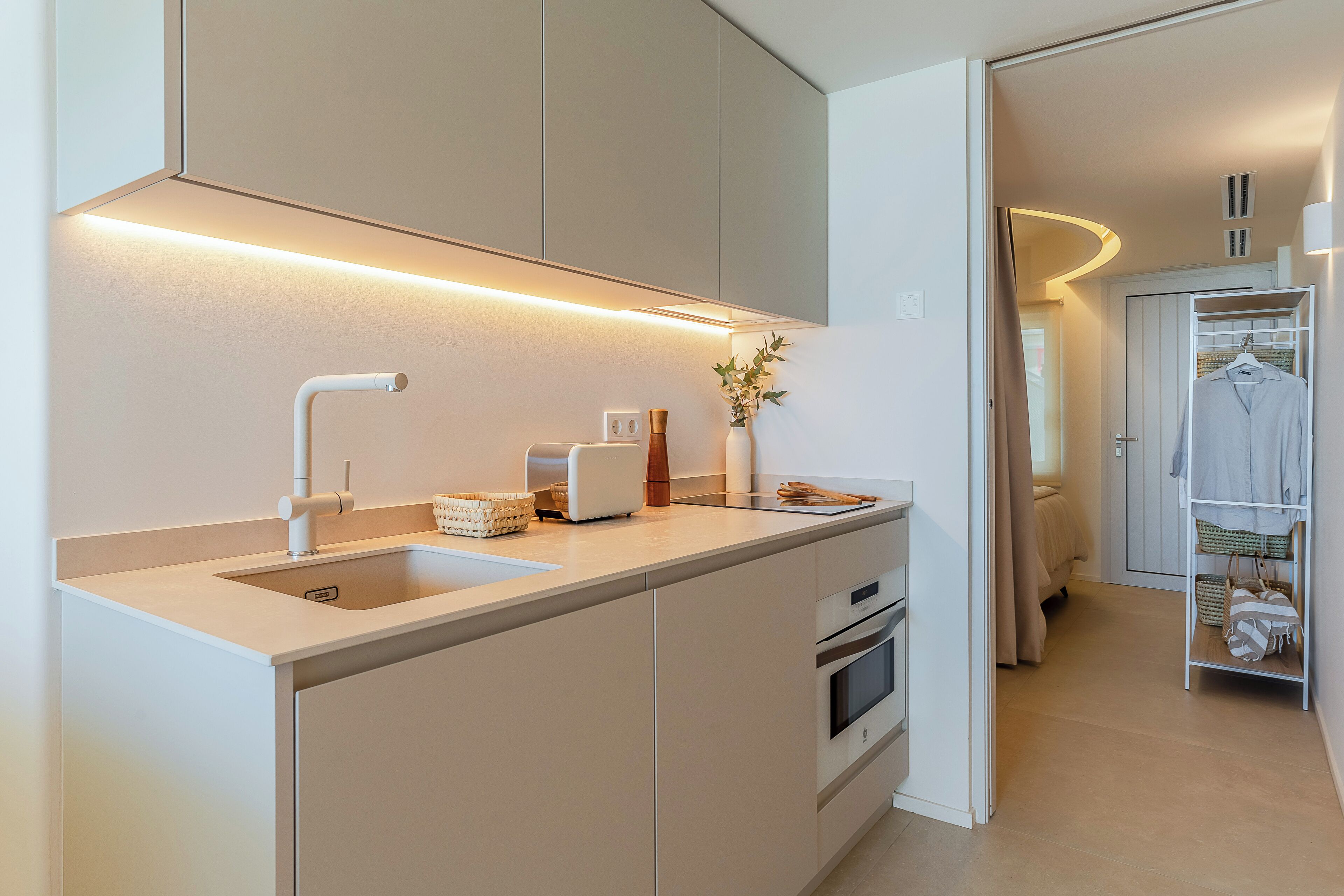 A modern kitchen with a built-in sink, a toaster, and a vase with flowers.