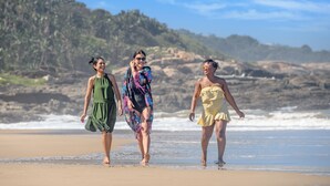 Three people walking on a beach with rocky cliffs in the background. - San Lameer Villa 2532 (Southbroom)