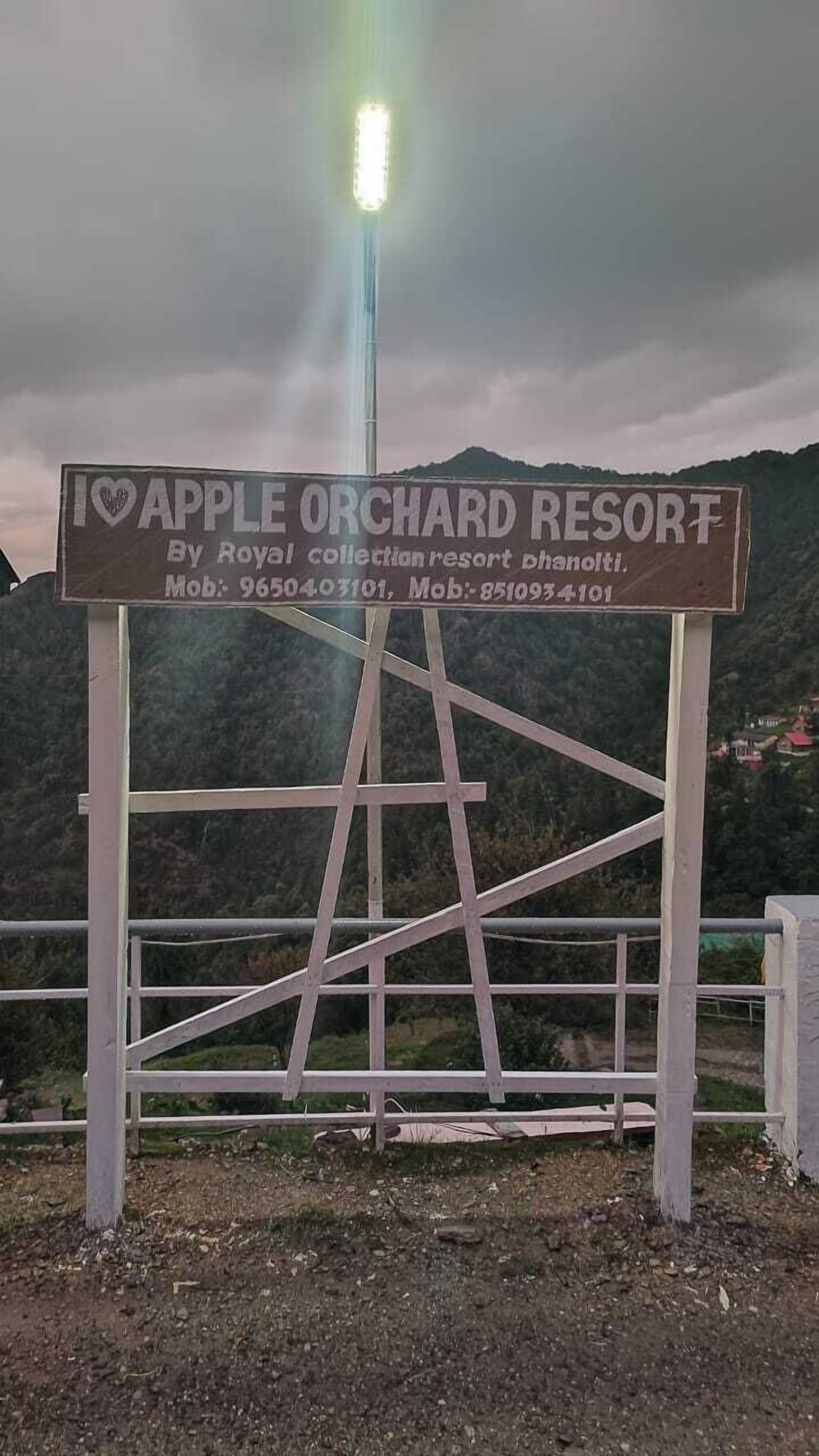 A sign for Apple Orchard Resort with contact numbers.