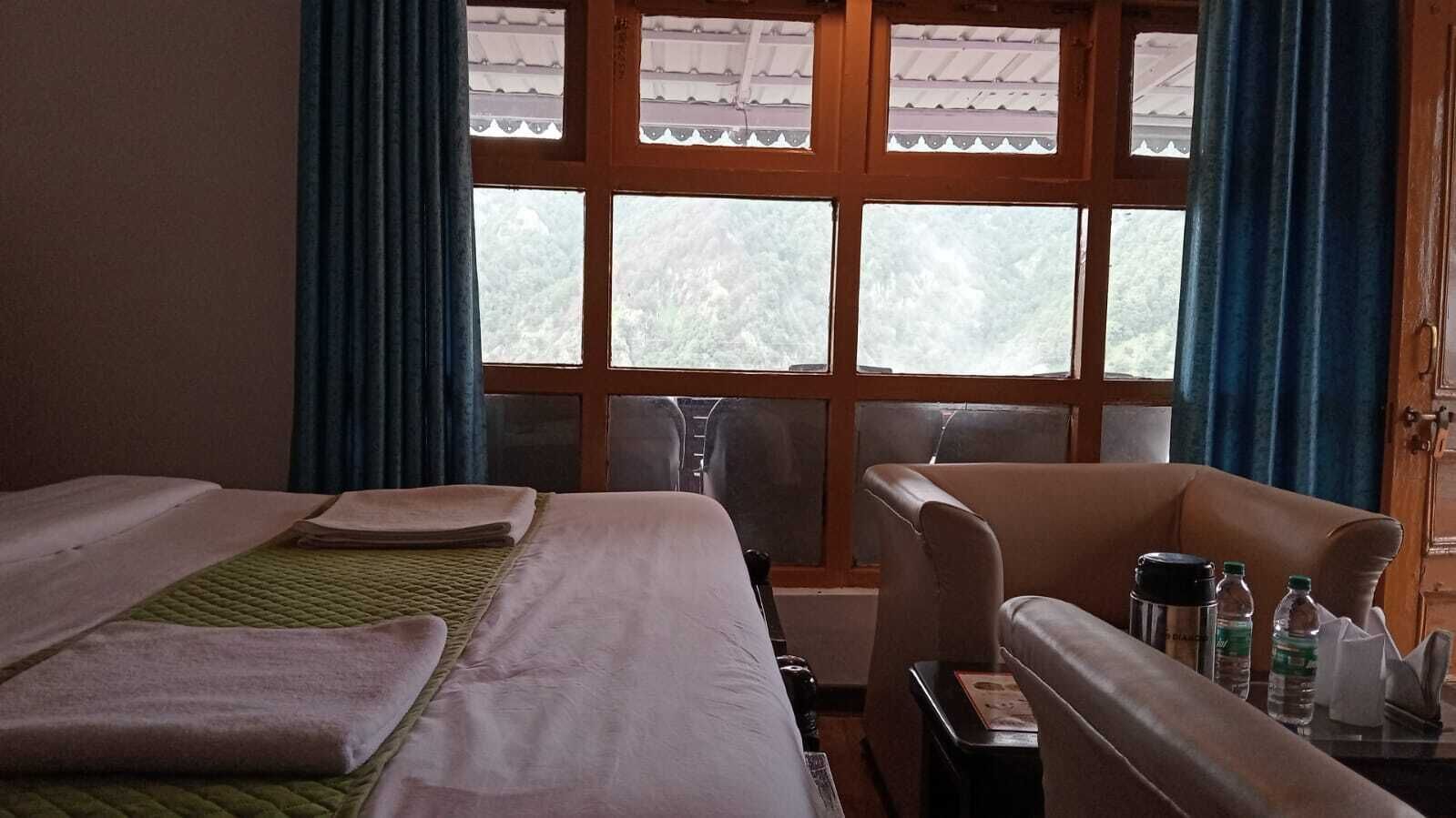 A hotel room with two beds, a desk, and a chair.
