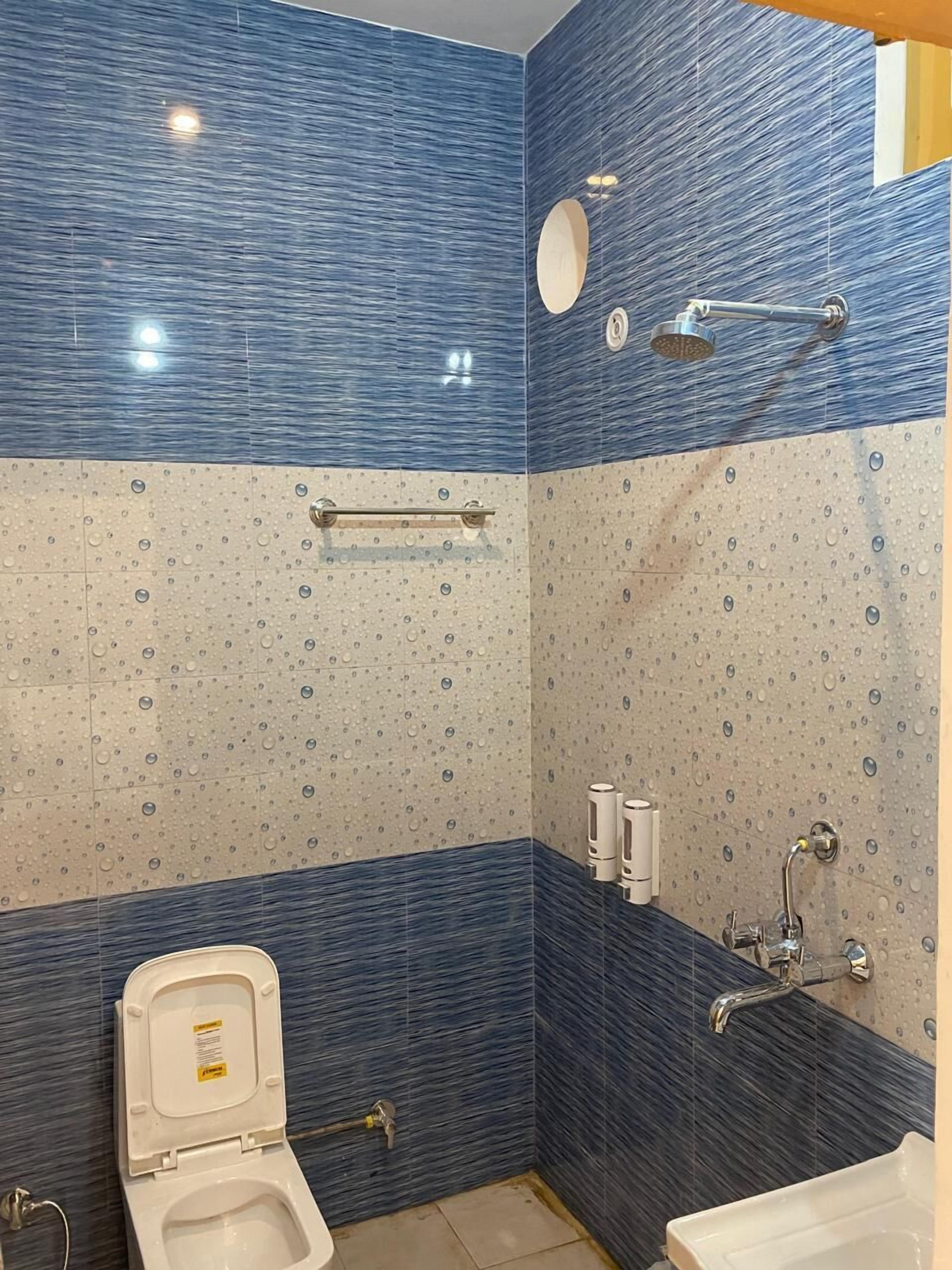 A bathroom with a toilet, sink, and shower.