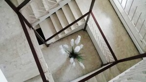 Un escalier en marbre, doté d’une rampe au motif géométrique, menant à l’étage supérieur.