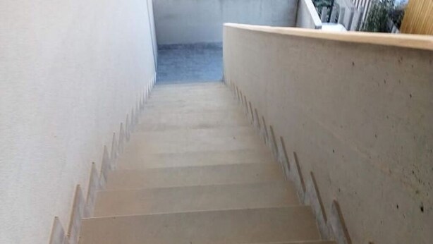 Una escalera de hormigón con barandilla en el lado derecho.