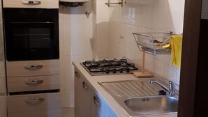 Una cocina con estufa, lavaplatos y horno.