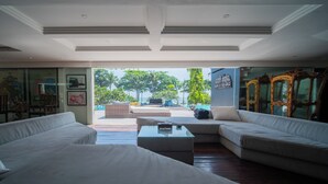 A spacious living area with a large sofa set, a coffee table, and a view of the outdoor patio. - Morabito Art Villa (Tibubeneng)