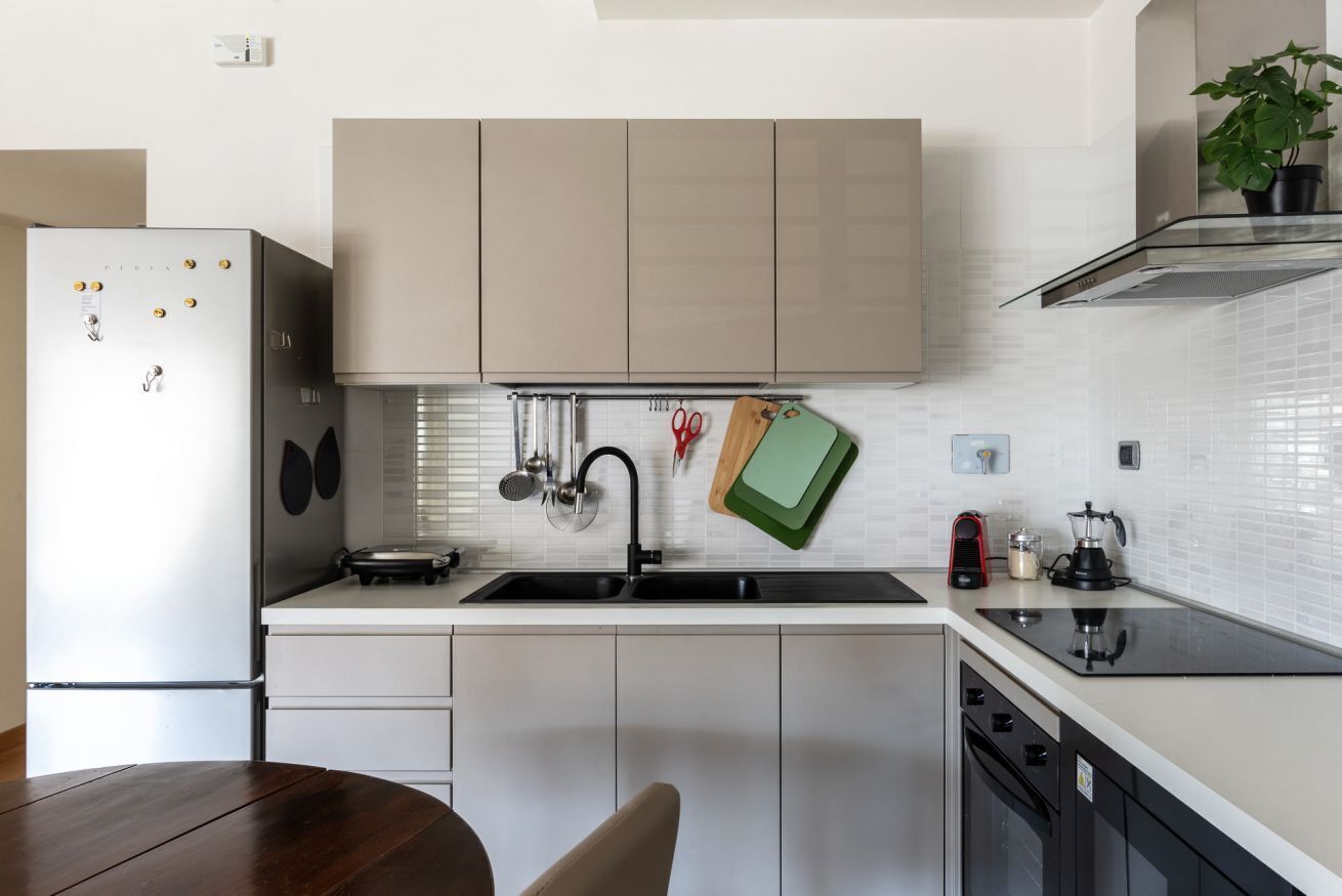 A modern kitchen with a built-in dishwasher, a sink with a faucet, and a stove.