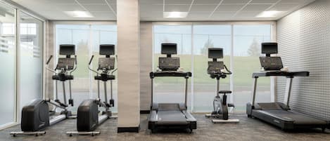 A gym with treadmills, elliptical machines, and stationary bikes.