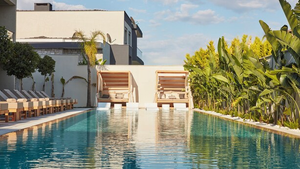 A swimming pool with lounge chairs and a building in the background. - VENZI AYAYORGI ADULT ONLY +15 (Cesme)