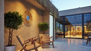 A patio area with wicker chairs, potted plants, and a thatched roof. - VENZI AYAYORGI ADULT ONLY +15 (Cesme)