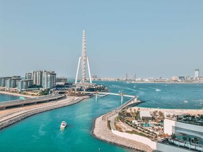 A coastal cityscape with a prominent tower, a marina, and modern buildings. - Luxury Marina View 2BR Flats Dubai by Belvilla (Dubai)