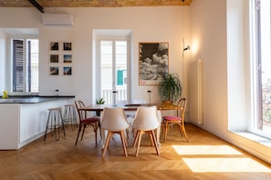 Una cocina moderna con una isla central, taburetes de bar y una mesa de comedor con sillas.