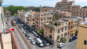 A street view of a city with buildings, vehicles, and a tram.