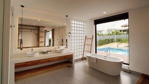 A modern bathroom with a freestanding bathtub, a large mirror, and a white sink. - The Pine Mansion (Sen Monorom)