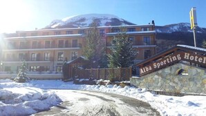 A hotel with a stone facade and a sign reading "Alba Sporting Hotel". - ALBA SPORTING HOTEL (Rocca di Mezzo)