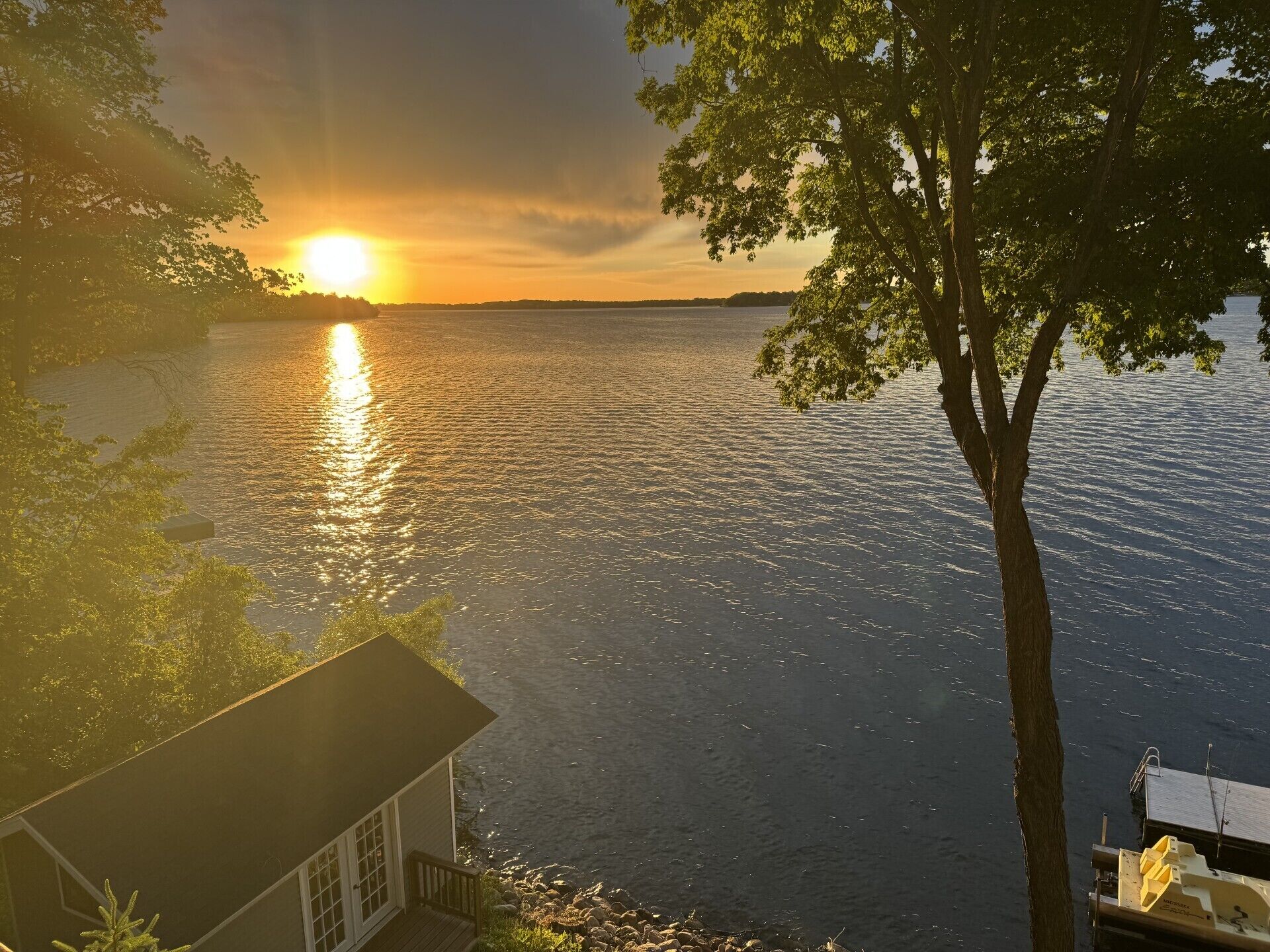 Une vue sur le lac avec une maison et un quai.