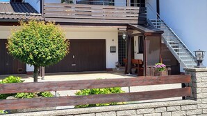 A two-story house with a balcony, a staircase, and a garage. - Neu Renovierte Ferienwohnung, 50qm, mit Vollausgestatteter Küche (Eggstätt)