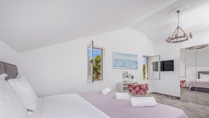 Une chambre moderne avec un grand lit, une coiffeuse avec un miroir et un lustre.