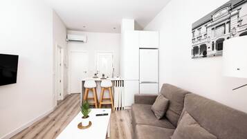 A modern apartment with a kitchen, a living area, and a dining space.