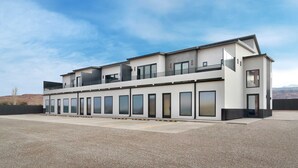A modern two-story building with a flat roof, large windows, and a balcony on the upper floor. - Vizcaya #7 - Moab's Newest Luxury Rental (Moab)