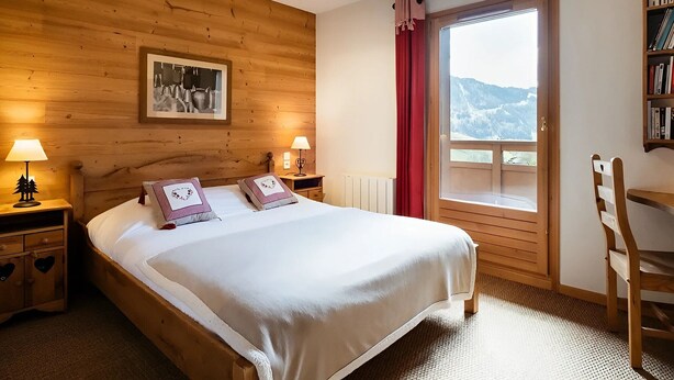 Ein Schlafzimmer mit Holzwänden, einem Bett, zwei Nachttischlampen, einem Fenster mit Blick und einem Bücherregal.