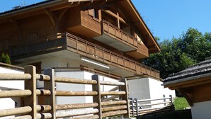 Eine Holzhütte mit Balkon, Schornstein und Holzzaun.