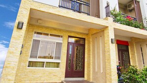 A multi-story building with a symmetrical facade, large windows, and balconies. - Kuan-Pin B&B (Wujie)