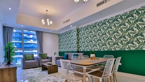 A modern living room with a dining area, large windows, and a green patterned wall. - Apartment Downtown Dubai Near Burj Khalifa (Dubai)