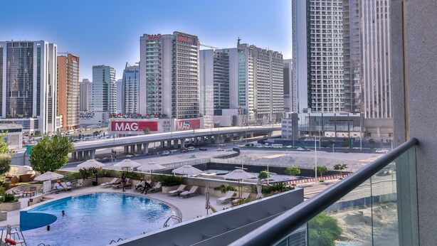 A high-rise building with a swimming pool and lounge area. - Apartment Downtown Dubai Near Burj Khalifa (Dubai)