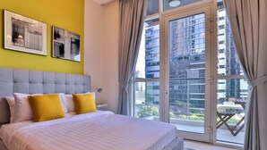 A modern bedroom with a large bed, a city view through the glass door, and artwork on the wall. - Apartment Downtown Dubai Near Burj Khalifa (Dubai)