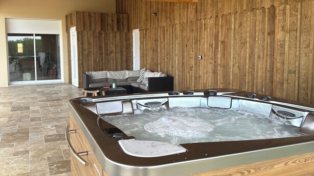 Et spa-område med jacuzzi, trævægge og flisegulv.